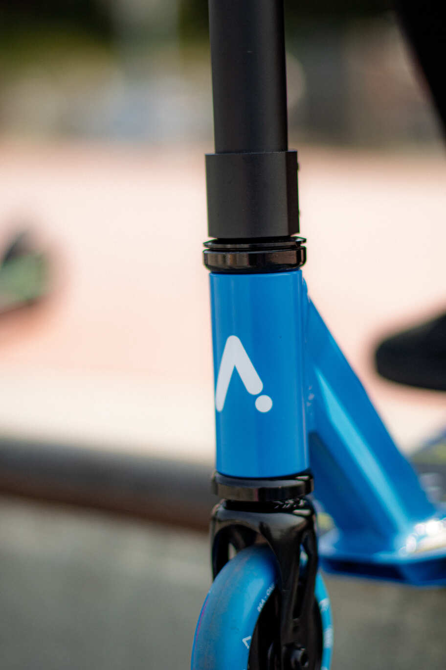 Tube de direction bleu d'une trottinette freestyle ACTA, gros plan sur le logo