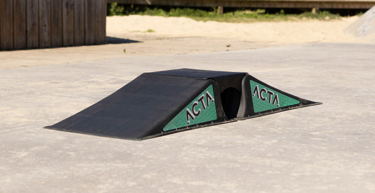 Rampe ACTA noire et verte posée sur le béton d'un skatepark